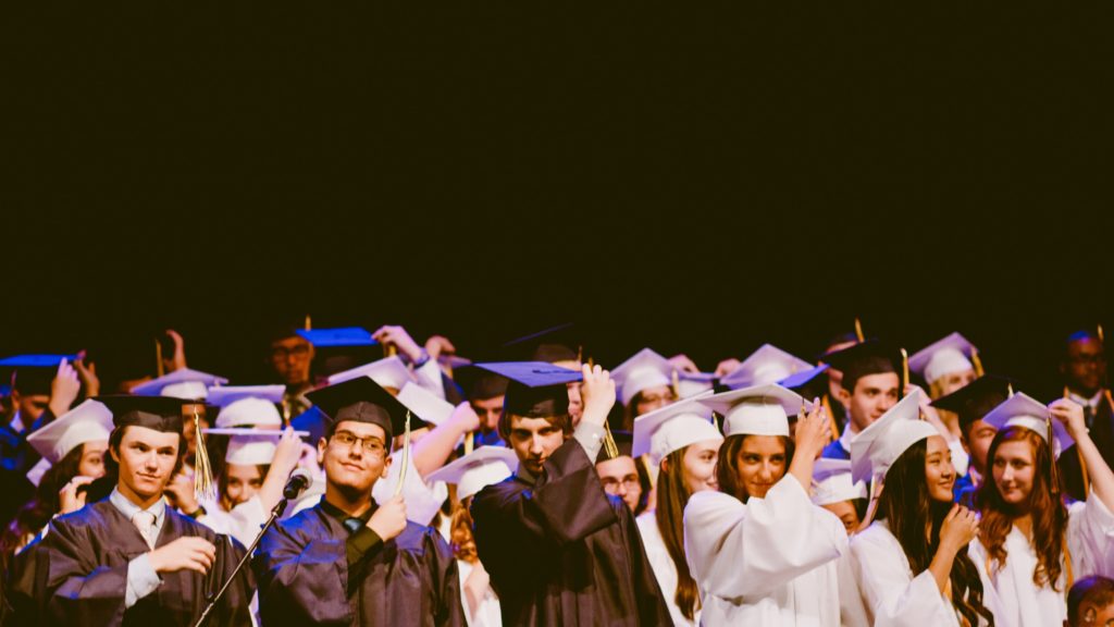 Group of young men and women in caps and gowns.