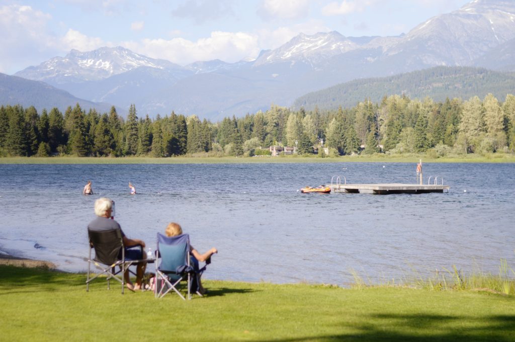 An older couple in lawn chairs looking at a lake